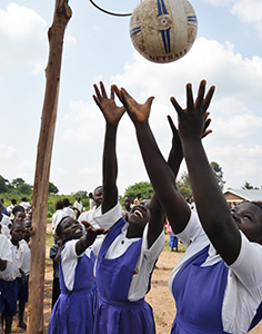 Schulmädchen in Uganda spielen in der Pause Korbball.